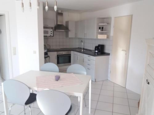 a white kitchen with a white table and chairs at Oberhof in Bodman-Ludwigshafen