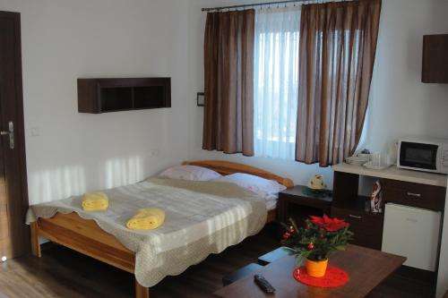a small bedroom with a bed and a table at Wanta in Bukowina Tatrzańska
