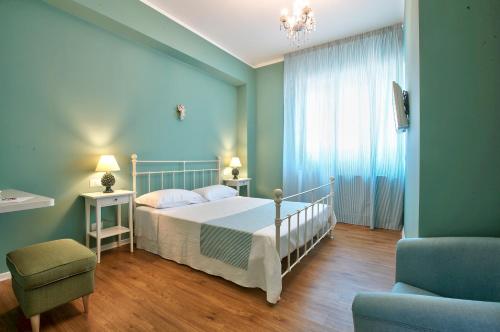 a bedroom with a bed and a couch and a chair at B&B Del Corso in Capo dʼOrlando