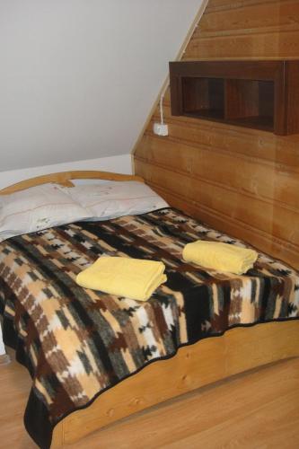 a bed with two yellow towels on top of it at Wanta z pyszną karczmą in Bukowina Tatrzańska