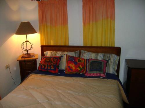 a bedroom with a bed with pillows and a lamp at Jardin Secreto Russell Maipu in Mendoza