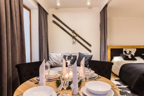 - une salle à manger avec une table et un lit dans l'établissement Apartament Czarny Staw, à Zakopane