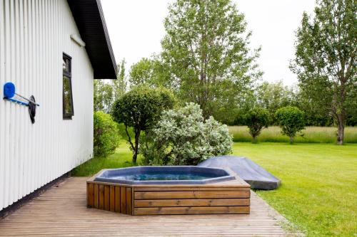 a hot tub on a deck next to a house at South Central Country-Apartment in Brautarholt
