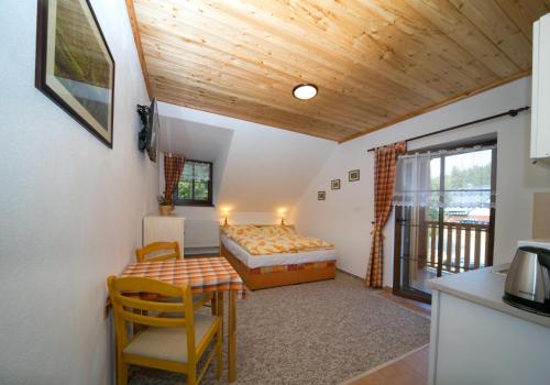 a bedroom with a bed and a table in a room at Chata u Tří Sluk in Modrava