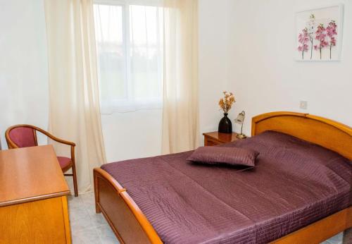a bedroom with a bed with a purple blanket at Pafia 3 Holiday Apartment in Paphos City