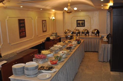 una línea de buffet con platos y tazones de comida en Al Zaitouna Hotel, en Áqaba