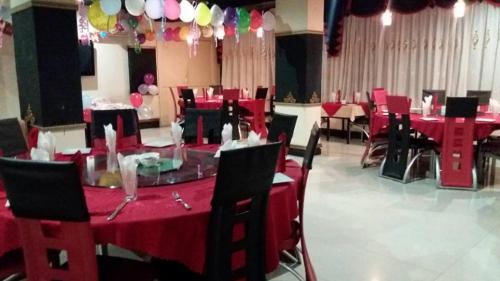 a dining room with red tables and chairs and balloons at Urban Rose Hotel & Apartments in Dar es Salaam
