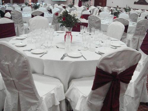 a white table with white chairs and tables with glasses at Urban Rose Hotel & Apartments in Dar es Salaam
