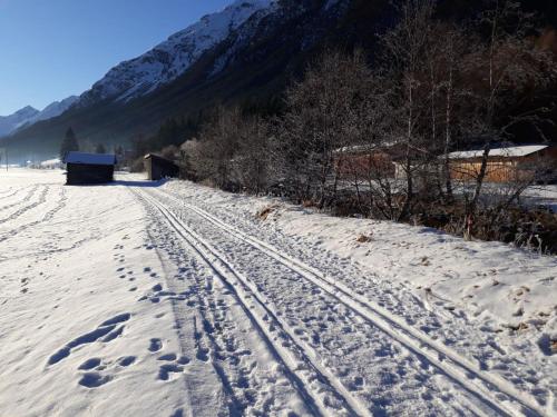 a snow covered field with tracks in the snow at Katja´s Ferienwohnung in Trins