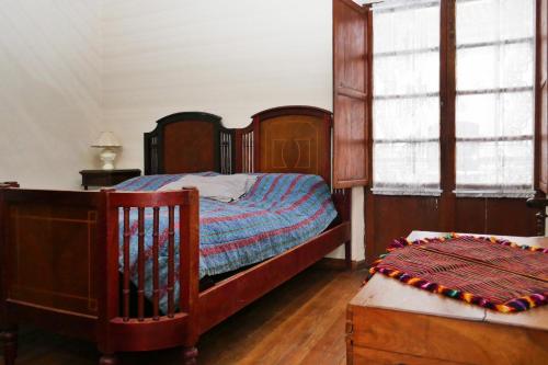 a bedroom with a wooden bed and a window at Casa Ramirez - Guest House en el Segundo Piso in Sucre