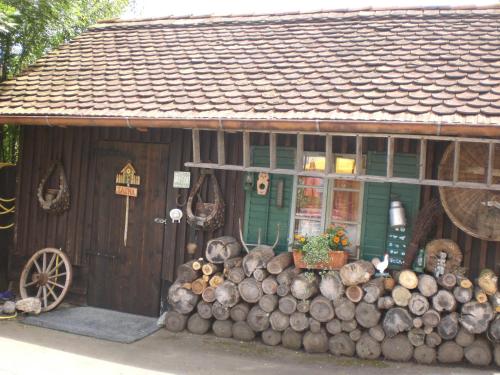 a building with a pile of logs in front of it at FerienAppartments Landhaus FühlDichWohl in Fehring