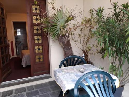a table and chairs in front of a house with plants at La Caravelle in Riom