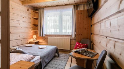um quarto com 2 camas num quarto de madeira em Pokoje Gościnne Chochołów em Chochołów
