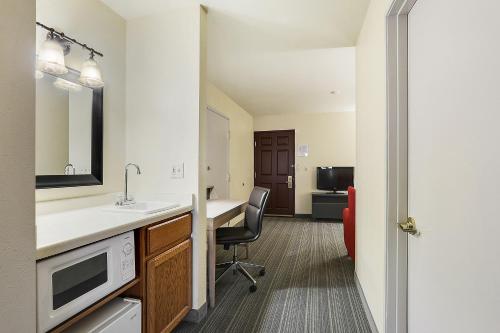 a kitchen with a desk and a chair in a room at Country Inn & Suites by Radisson, Green Bay, WI in Ashwaubenon