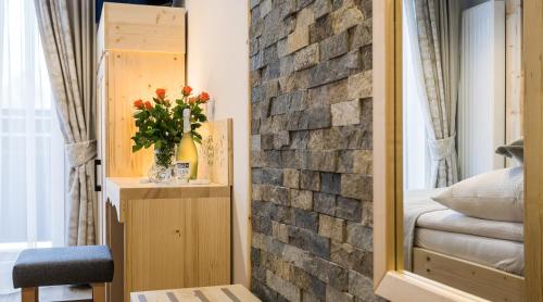 a bedroom with a brick wall and a mirror at Pokoje Gościnne Chochołów in Chochołów