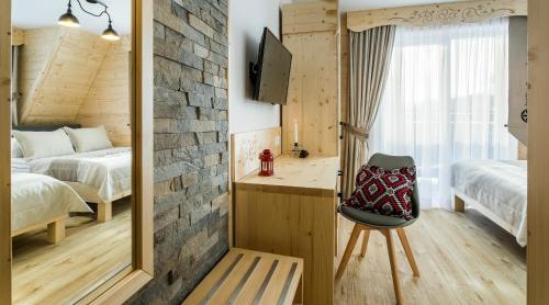 a bedroom with two beds and a mirror and a chair at Pokoje Gościnne Chochołów in Chochołów