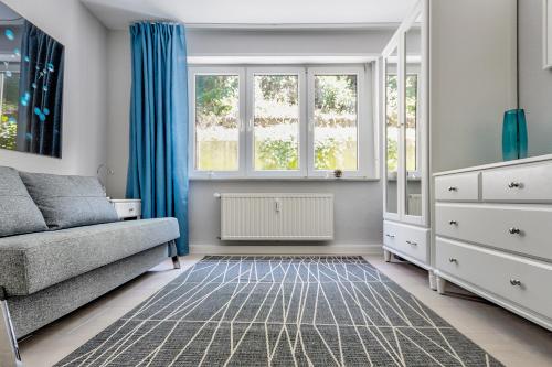 a living room with a couch and windows at Charming CHARLOTTE in Saarbrücken