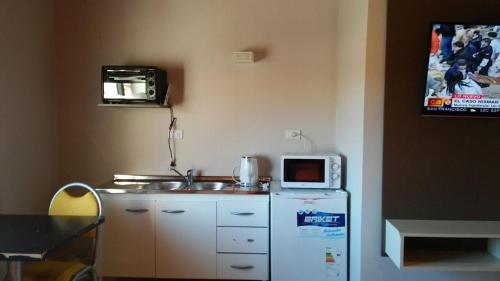a small kitchen with a microwave and a refrigerator at Aparts Piscu Yaco Almendros in Merlo