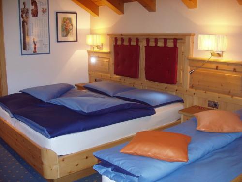 a bedroom with two beds with blue pillows at Appartamenti Loretta in La Villa