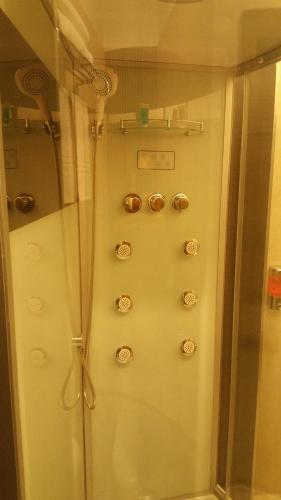 a shower with a glass door with buttons on it at Baku Sea View Hotel in Baku