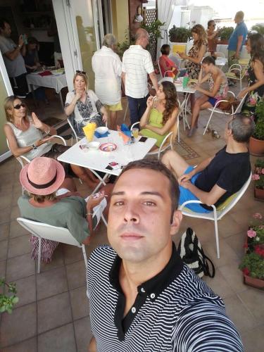 a man sitting at a table in front of a group of people at B&B Celestina Ischia in Ischia
