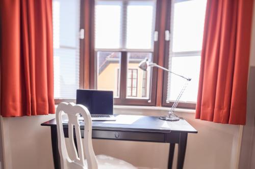 a desk with a laptop and a chair in front of a window at Charming FRIEDA in Maybach