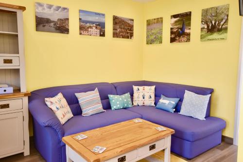 a living room with a purple couch with pillows at Creek View in Wootton Bridge