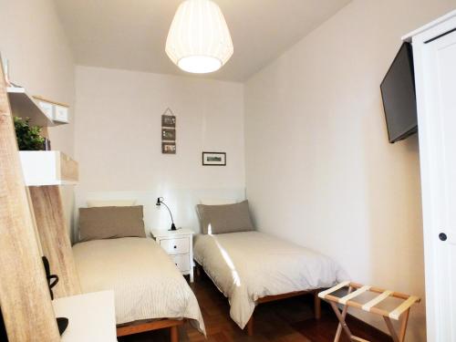 1 dormitorio con 2 camas y TV en Sleep & Fly en Bolonia