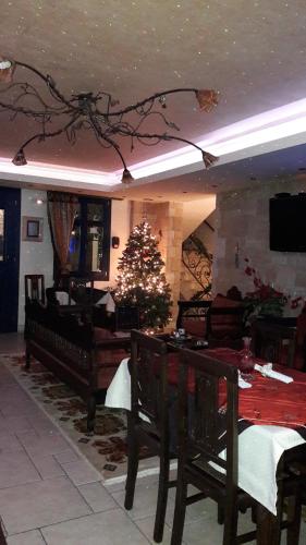 a living room with a christmas tree and a dining table at ''EPAVLIS boutique GALAXIDI'' in Galaxidhion