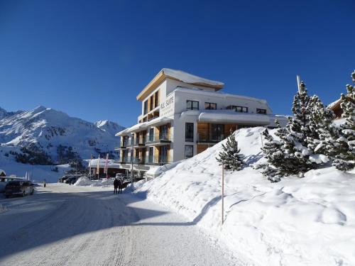 a building on a snow covered slope with trees in front at Modern ski-in Appartement 2020m Kühtai in Kühtai