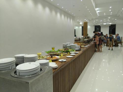 a buffet line in a restaurant with plates and food at Nice Place Resort in Dambulla