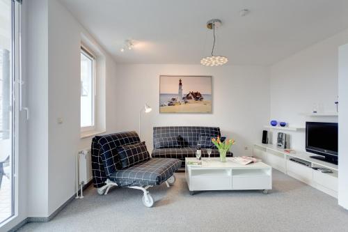 a living room with two chairs and a tv at Möwe in Göhren