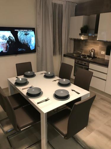 a white table with chairs and a tv in a kitchen at Loft Sirmione in Sirmione