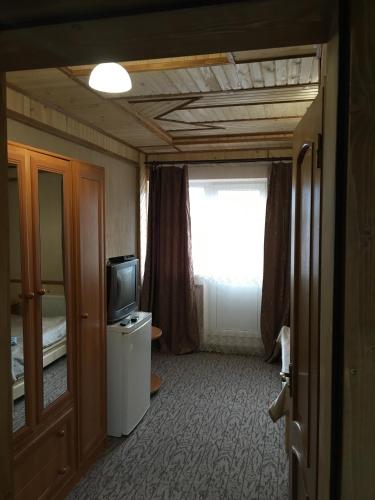 a small room with a television and a window at Skarbivka in Vorokhta