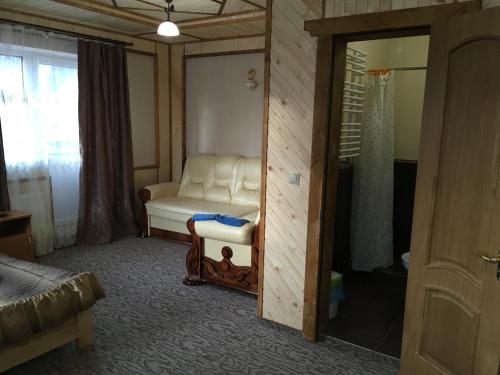 a living room with a white chair and a mirror at Skarbivka in Vorokhta