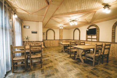 una sala da pranzo con tavoli e sedie in legno di Skarbivka a Vorokhta