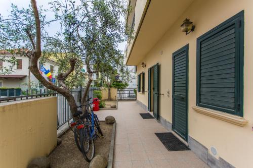 a bike parked next to a building with green doors at Residence Kimba in Rimini