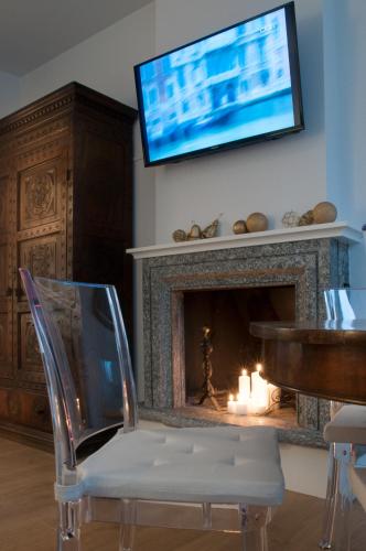 a living room with a fireplace with a television above it at Relais Merizzi in Tirano