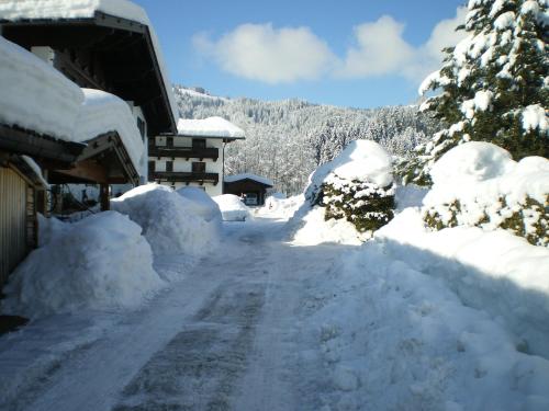 a road covered in snow next to a house at Marie Luise, Landhaus in Reith bei Kitzbühel