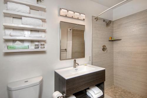 a bathroom with a sink and a toilet and a mirror at The Inn at Pasatiempo in Santa Cruz