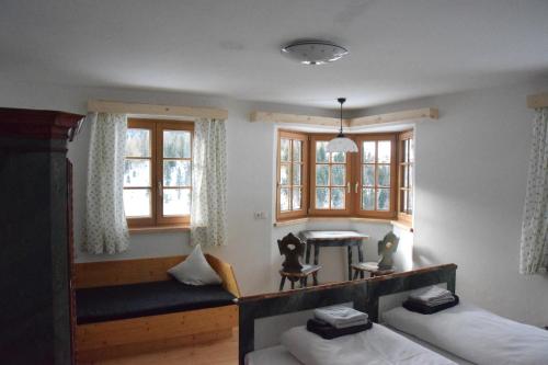 ニーダートハイにあるHaus Christianのベッド2台、テーブル、窓が備わる客室です。