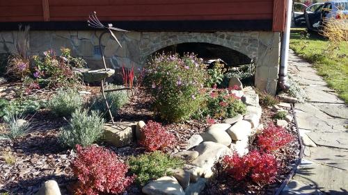 a garden with flowers and rocks in a yard at Dom wakacyjny Podlas in Żywiec