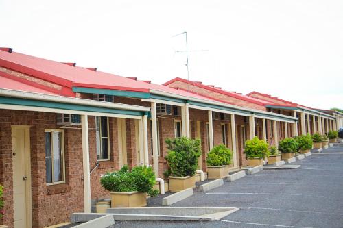 a row of brick buildings with potted plants on them at Motel 359 in Tamworth