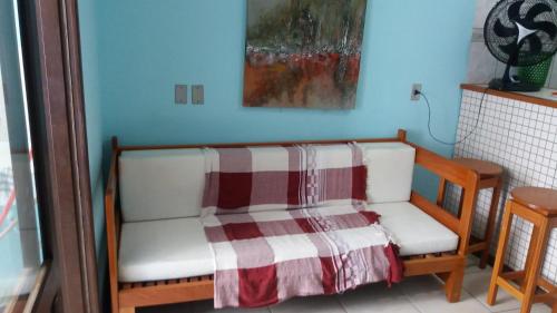 a room with two white chairs with a blanket at Sobrado Hibisco in Capão da Canoa