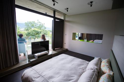 a living room with a couch and a large window at One Piece B&B in Dongshan
