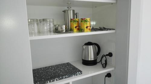 a kitchen shelf with a coffee maker on it at Villa on Milton in Nelson