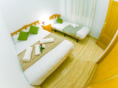 トレビエハにあるHomely Apartments Blasco Ibañezのベッドルーム1室(ベッド2台、白いシーツ、緑の枕付)
