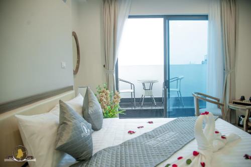 a bedroom with a bed with a view of a balcony at The Pilgrim Hotel in Hanoi