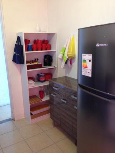La cuisine est équipée d'un réfrigérateur noir et d'une armoire. dans l'établissement Mumus, à La Serena