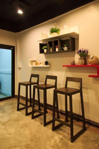 three chairs in a room with a wall with shelves at T2 Hostel Thappraya 12 in Pattaya South
